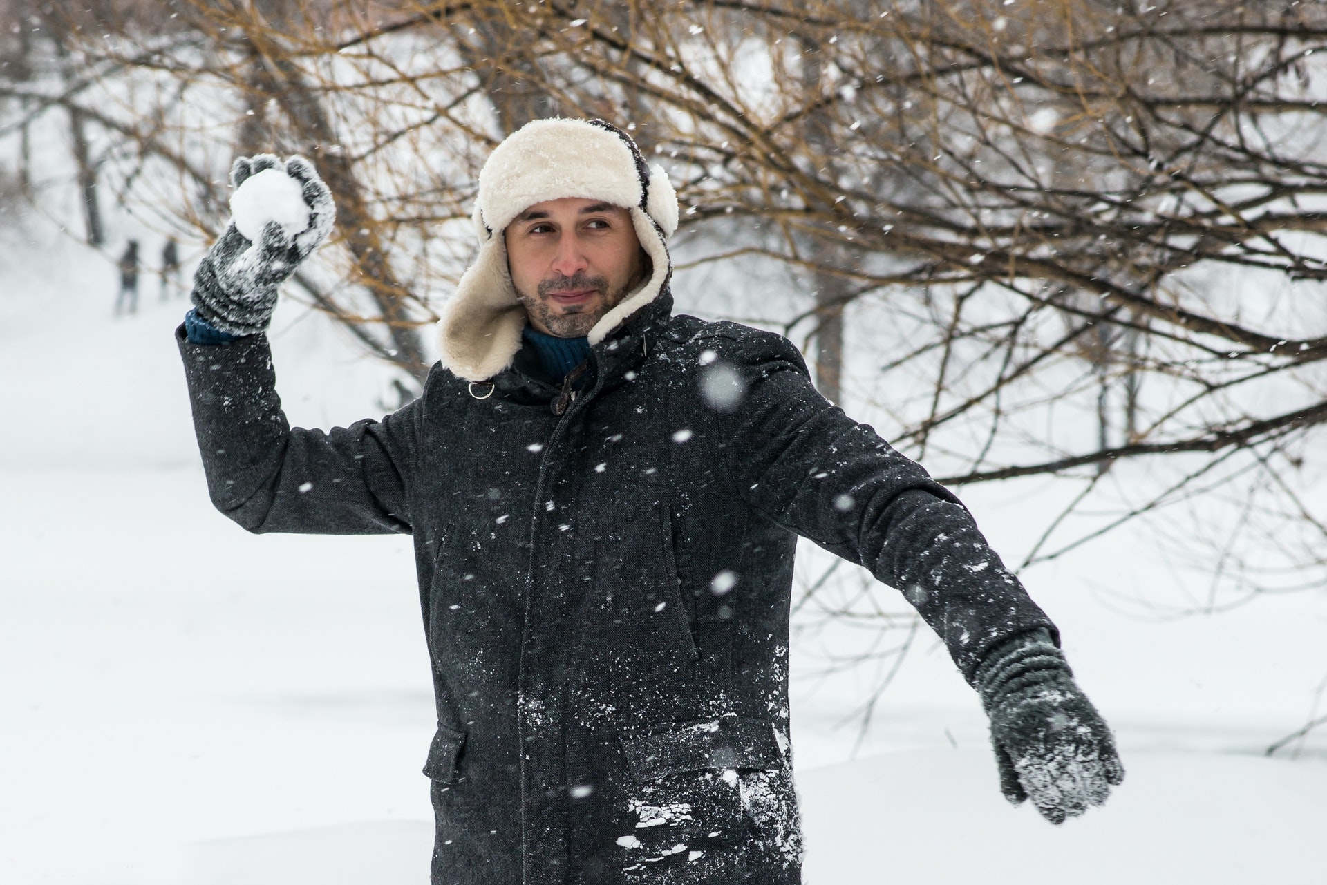 Kurtki zimowe męskie - mężczyzna rzuca śnieżkami