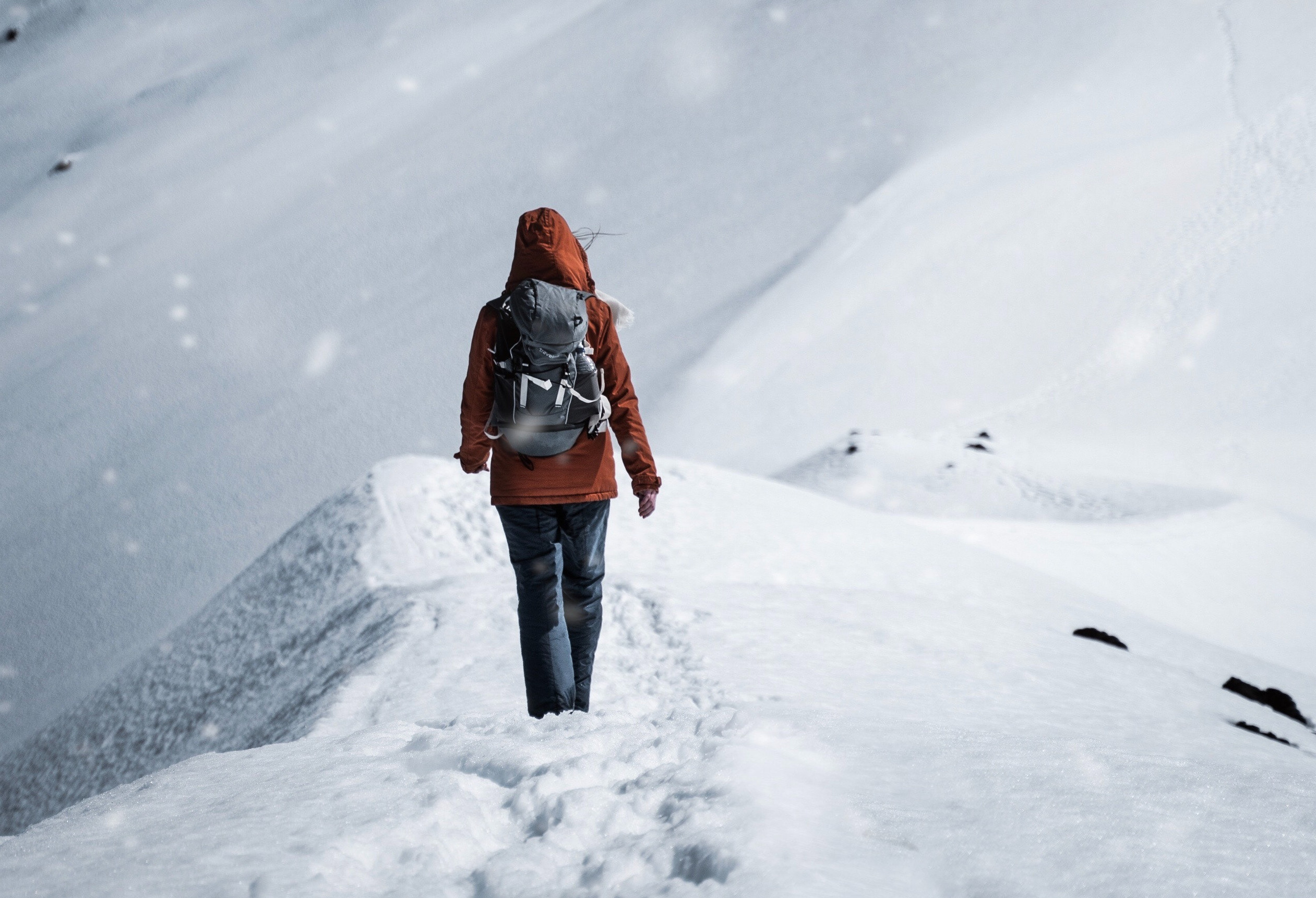 Kobieta spacerująca po śniegu w górach