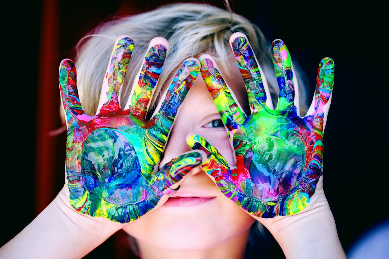 Dziecko z kolorową farbą na dłoniach